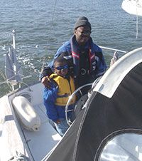 Father and son at the helm of a sailboat
